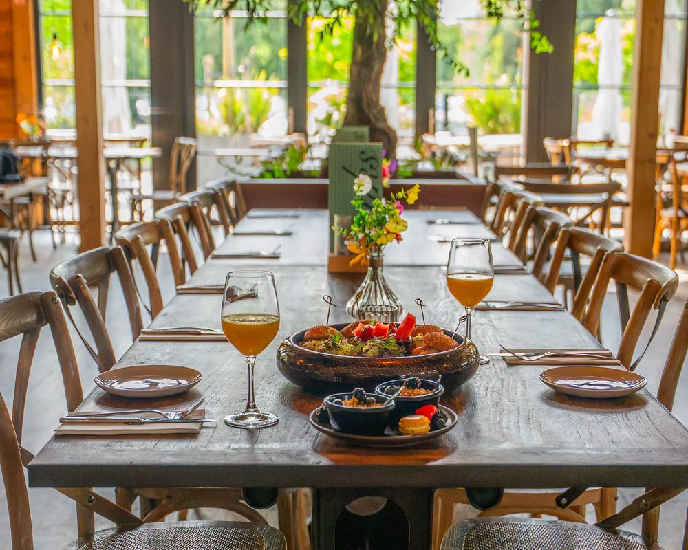 Gedekte lange tafel met lunchgerechten en groen