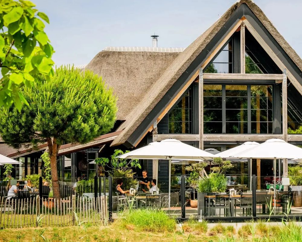 Venneper Lodge met rieten dak tussen het groen
